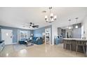 Spacious living room featuring a large ceiling fan and opening to a bright kitchen at 1489 77Th N Ave, St Petersburg, FL 33702