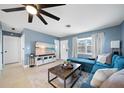 Inviting living room with a large smart TV, ceiling fan, and comfortable blue sofa at 1489 77Th N Ave, St Petersburg, FL 33702