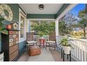 Inviting front porch offers a cozy seating area with neutral rug, stylish furniture and potted plants at 202 13Th N Ave, St Petersburg, FL 33701