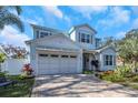 Charming two-story home featuring a well-manicured lawn, beautiful landscaping, and a spacious driveway at 230 Tucker St, Safety Harbor, FL 34695
