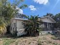 A cozy one-story home featuring a screened porch and lush tropical plants at 3201 N 15Th St, Tampa, FL 33605
