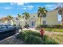Bright condo exterior featuring palm trees, well-maintained landscaping, and a designated parking area at 5092 Beach Se Dr # D, St Petersburg, FL 33705