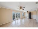 Spacious living room with tile flooring, ceiling fans, and balcony access through glass doors at 5092 Beach Se Dr # D, St Petersburg, FL 33705