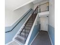 Hallway with carpeted stairs, black metal handrails, and white and blue painted walls at 5092 Beach Se Dr # D, St Petersburg, FL 33705