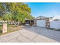 Beautiful single-Gathering home with stone details, mature trees, and a driveway leading to the attached garage at 6304 Seabreeze Dr, Port Richey, FL 34668