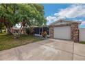 A lovely single-story home with stone accents, a garage, and lush landscaping for curb appeal at 6304 Seabreeze Dr, Port Richey, FL 34668