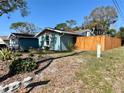 Exterior view of the home featuring a fenced yard, fresh paint, and updated windows at 7101 Channelside N Ln, Pinellas Park, FL 33781