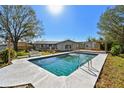 Backyard featuring a sparkling pool, a covered wooden deck, and lush landscaping at 8555 81St Way, Largo, FL 33777