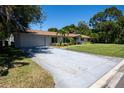 Single-story home boasting an attached garage and mature trees surrounding the property at 2391 66Th S Ter, St Petersburg, FL 33712