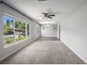 Bright living room features large window with outside view, ceiling fan, and neutral paint at 2391 66Th S Ter, St Petersburg, FL 33712