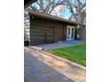 Quaint outdoor patio area with brick pavers, seating, and lush landscaping at 3010 County Road 31, Clearwater, FL 33759