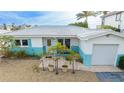Quaint single story home with teal and white exterior, attached garage, and small patio at 1425 Corey S Way, South Pasadena, FL 33707