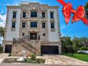 Luxury home with stone facade, grand staircase, and a red ribbon at 3087, 3075 Cherry Ln, Clearwater, FL 33759