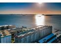 Expansive aerial view of buildings, the ocean, and a pier at sunset at 634 Edgewater Dr # 644, Dunedin, FL 34698