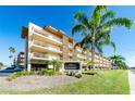 Exterior view of The Islander condo building, featuring palm trees at 105 Island Way # 121, Clearwater Beach, FL 33767