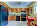 Functional kitchen features tile floor, wood cabinets and black appliances at 403 Gulf Way # 504, St Pete Beach, FL 33706