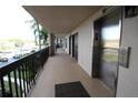 Hallway exterior view of building with elevator and palm tree views at 1806 Mariner Dr # 214, Tarpon Springs, FL 34689