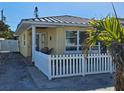 Charming yellow house with a white picket fence and spacious yard at 108 11Th Ave, St Pete Beach, FL 33706