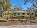 Street view of a single story home with light colored siding and a green front door and shutters at 679 Lake Maggiore S Blvd, St Petersburg, FL 33705