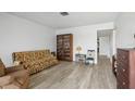 Living room with floral sofa, recliner, and wood floors at 5396 Acacia N Trl, Pinellas Park, FL 33782