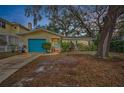 House exterior at dusk, teal garage door, and mature trees at 335 Tucker St, Safety Harbor, FL 34695