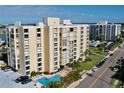 Aerial view of a waterfront condo building with pool and parking at 830 S Gulfview Blvd # 305, Clearwater Beach, FL 33767