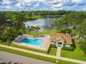 Community pool with clubhouse and lake view at 3051 Overlook Pl, Clearwater, FL 33760