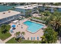 Aerial view of a large pool surrounded by lush landscaping and condominium buildings at 6201 2Nd E St # 73, St Pete Beach, FL 33706