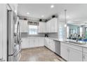 Modern kitchen featuring white cabinets, stainless steel appliances, and granite countertops at 3134 Francoa Dr, Odessa, FL 33556