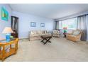 Bright living room featuring neutral tones, comfortable seating, and plenty of natural light from the large window at 1235 S Highland Ave # 2-204, Clearwater, FL 33756