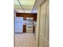 Efficient kitchen with white appliances and wood cabinets at 7050 Sunset S Dr # 203, South Pasadena, FL 33707