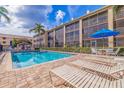 Community pool with lounge chairs and patio area at 465 Pinellas Bayway S # 307, Tierra Verde, FL 33715