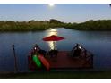 Waterfront home featuring private dock with umbrella, chairs, and kayaks for enjoying the serene river views at night at 1964 Arvis E Cir, Clearwater, FL 33764