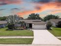 Single-story home with white exterior, landscaped yard, and attached garage at 2098 Swan Ln, Safety Harbor, FL 34695