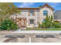 Front view of tan townhome with parking and landscaping at 103 Brigadoon Dr, Clearwater, FL 33759