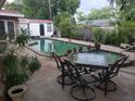 Inviting backyard pool area with ample seating and lush tropical landscaping at 8665 Mockingbird Ln, Seminole, FL 33777