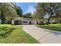 House exterior showcasing a driveway and lush green lawn at 12912 Willoughby Ln, Hudson, FL 34667