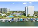 Aerial view of waterfront property with pool, tennis courts, and boat slips at 660 Island Way # 401, Clearwater, FL 33767