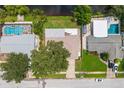 Aerial perspective showcasing three homes with pools and lush landscaping at 6087 16Th Ne Ln, St Petersburg, FL 33703