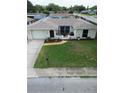 Charming single-story home boasts a well-manicured lawn and a welcoming front patio with stylish decor at 1172 Chelsea Ln, Holiday, FL 34691