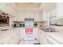 Efficient kitchen with white cabinets and appliances at 2400 Winding Creek Blvd # 25-101, Clearwater, FL 33761