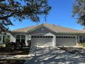 Two-car garage, light gray exterior, and well-maintained landscaping at 6926 Surrey Oak Dr, Apollo Beach, FL 33572