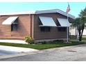 Side view of brown mobile home with American flag at 283 Pelican N Dr, Oldsmar, FL 34677