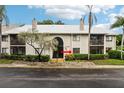 Condominium exterior with red arrow pointing toward unit entrance and well-maintained landscaping at 2085 Hunters Glen Dr # 213, Dunedin, FL 34698