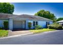 Front view of a single-story home with attached garage and well-maintained landscaping at 8356 Candlewood Rd # 0, Seminole, FL 33777