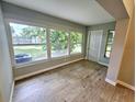 Bright sunroom with wood-look flooring, large windows, and a door to backyard at 8356 Candlewood Rd # 0, Seminole, FL 33777