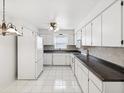 Bright kitchen with white cabinetry, tile flooring, and modern appliances creating a clean, functional space at 3332 Mcmath Dr, Palm Harbor, FL 34684