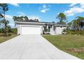 Single story home with grey exterior, white garage door and green grass at 9333 Hialeah Ter, Port Charlotte, FL 33981