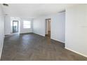 Open living area with herringbone floors and access to other rooms at 17734 1St E St, Redington Shores, FL 33708