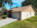 Tan house with 2-car garage and mature landscaping at 5930 Precious View Ct, New Port Richey, FL 34655